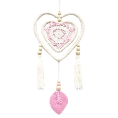 Atrapasueños El Bazar de Tizar en forma de corazón con tejido de crochet rosa, cuentas de madera y borlas blancas.