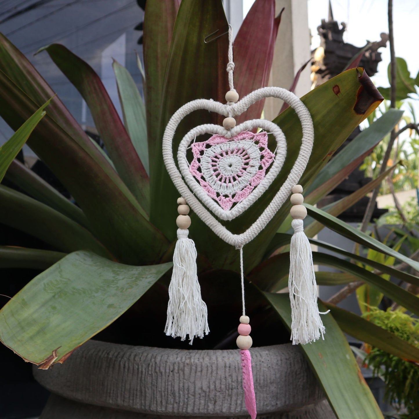 Atrapasueños El Bazar de Tizar con forma de corazón, tejido en macramé blanco y crochet rosa con cuentas de madera