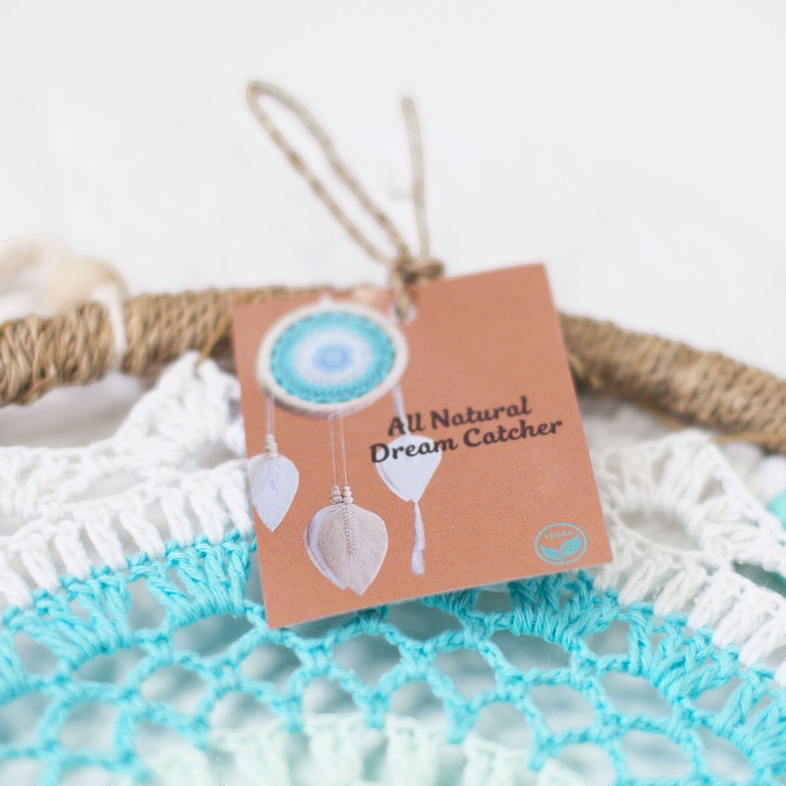 Atrapasueños El Bazar de Tizar con tejido de ganchillo en blanco y turquesa y etiqueta de producto natural